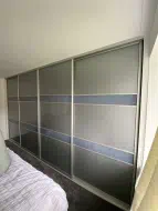 Stone grey glass doors with 2 shadow blue glass dividing bars per door in brushed champagne frames, fitted in Redcar